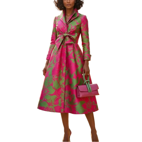 Woman in a pink and green coat standing in front of a chateau.