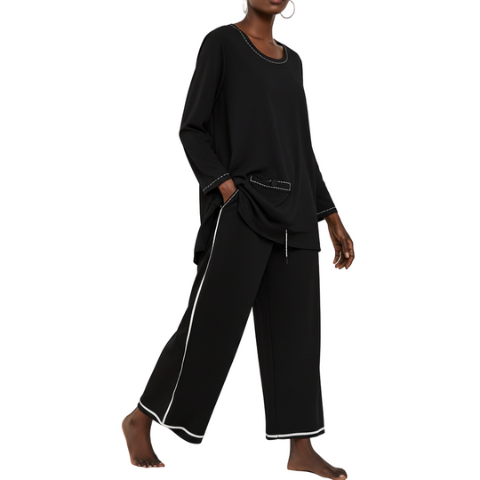 Black outfit with white trim worn by a model on a white background