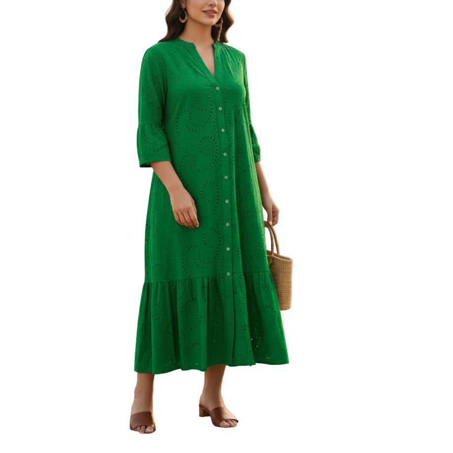 Woman in a green dress standing on a beach with a sunset in the background