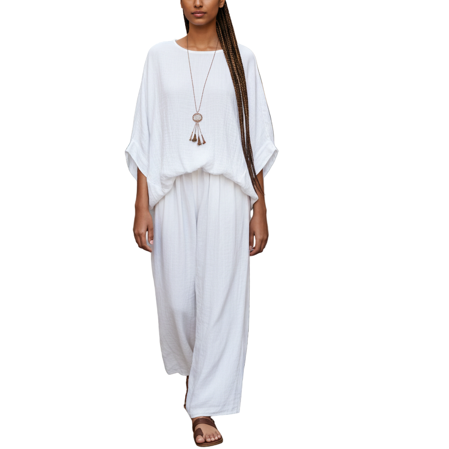 Woman in a white dress walking down a sunlit street.