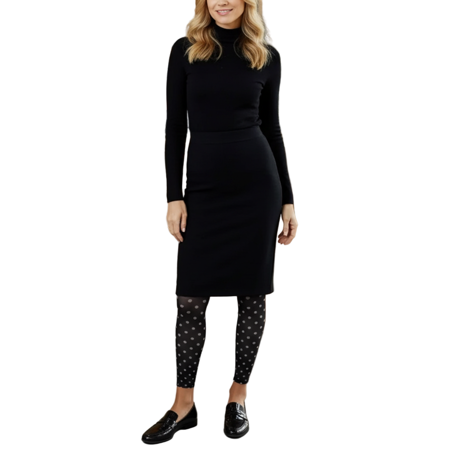 Woman in a black outfit standing in a coffee shop.