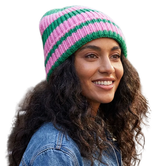Woman wearing a pink and green striped beanie on a city street