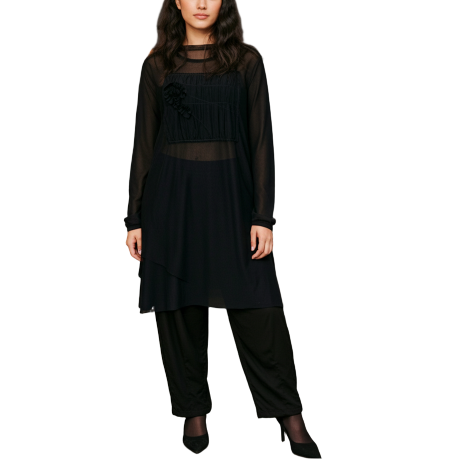 Woman in a black outfit standing in a modern interior setting