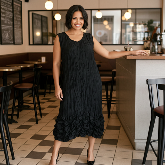 Woman in a black dress standing in a restaurant.
