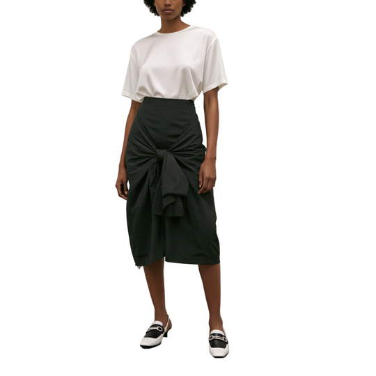 Woman standing in an art gallery with two paintings on the wall.