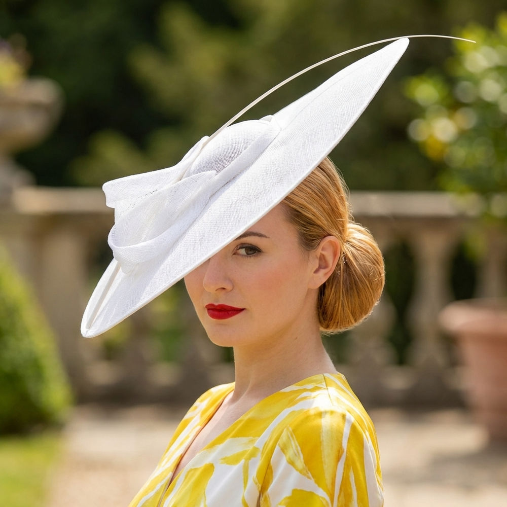 Woman wearing a large white hat with a yellow dress in an outdoor setting
