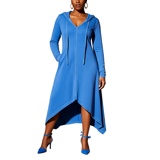 Woman wearing a blue dress with a hood in a room with a black sofa and lamp.