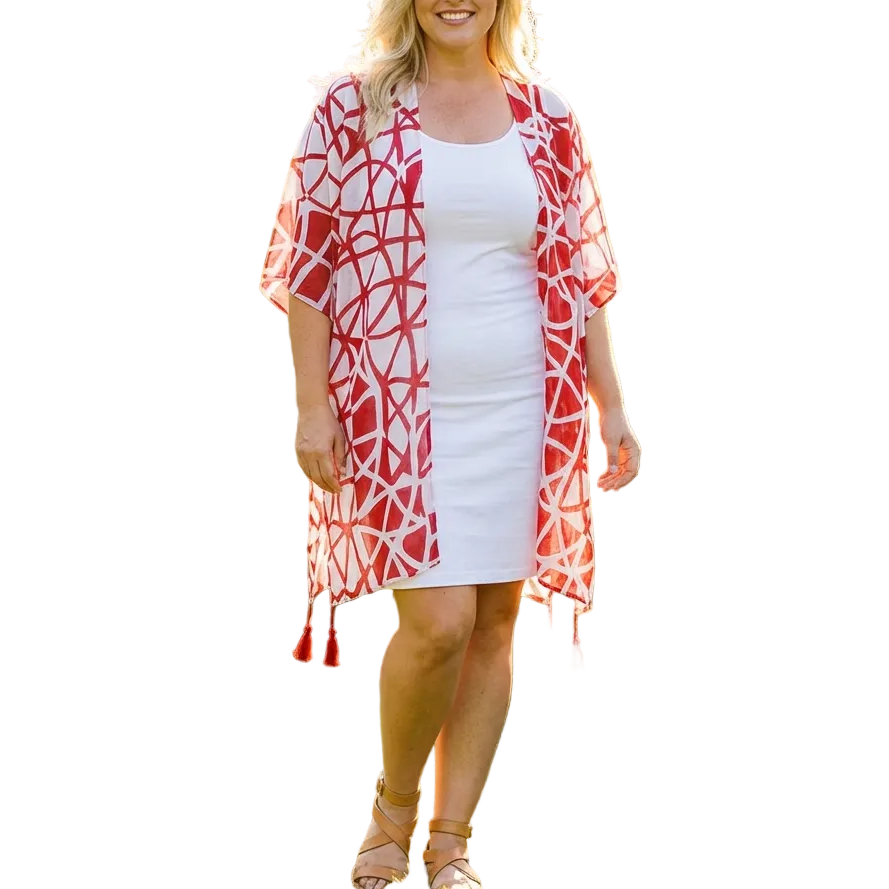 Woman wearing a red and white patterned kimono over a white dress in a garden setting
