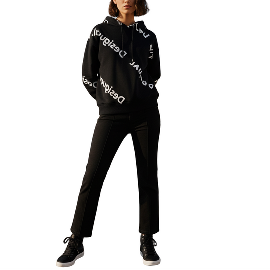 Person wearing a black hoodie with white text on a rooftop with cityscape in the background