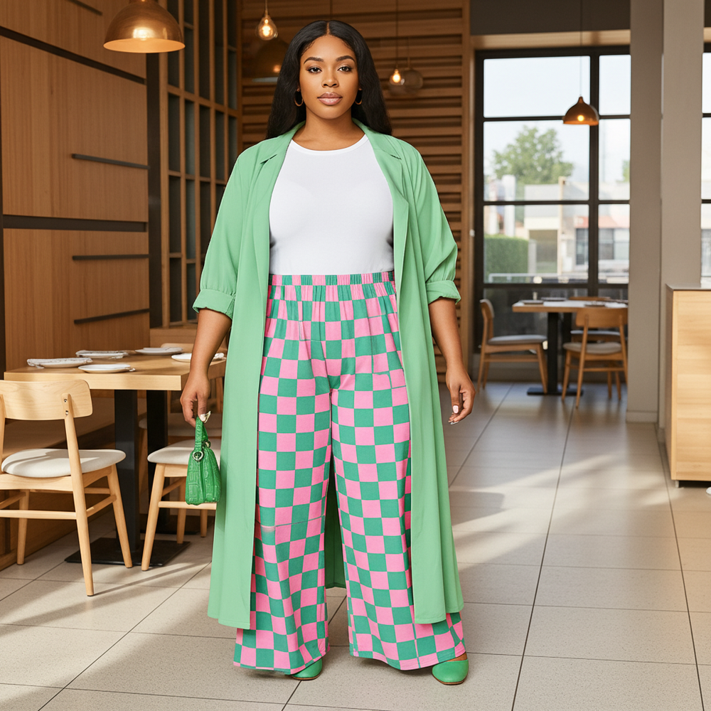 Woman in a green cardigan and pink checkered pants standing in a modern restaurant.