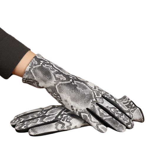 Snakeskin-patterned gloves on a wooden surface with books in the background