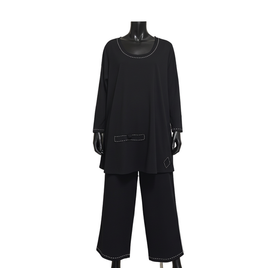 Black outfit on a mannequin in a clothing store setting with racks of clothes and mirrors in the background.