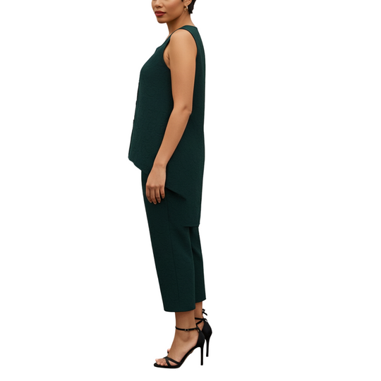 Woman in a green dress standing in an art gallery with artworks on the walls.