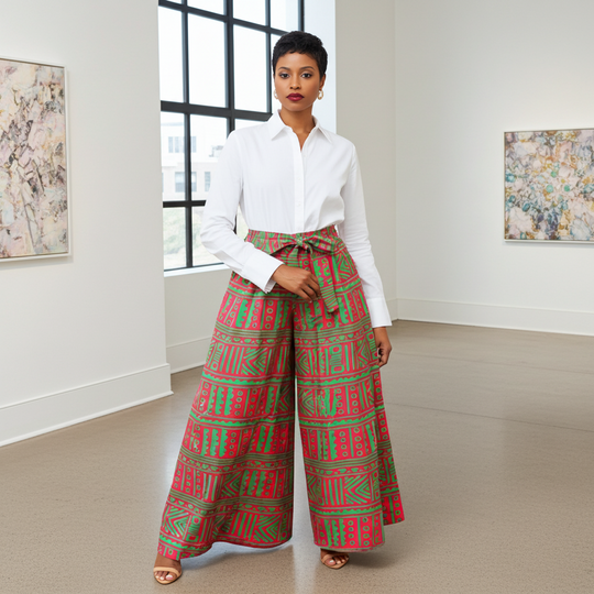 Woman wearing a white shirt and red and green patterned pants in a room with large windows.