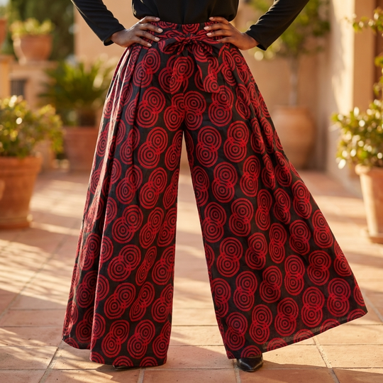 Person wearing red and black patterned wide-leg pants outdoors.
