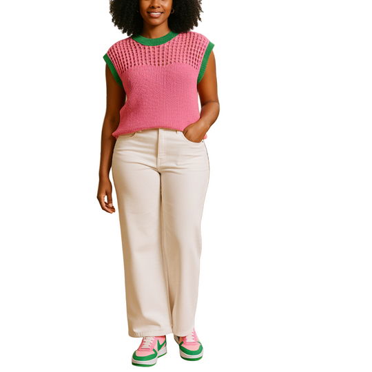 Woman standing in a greenhouse with plants and flowers around her