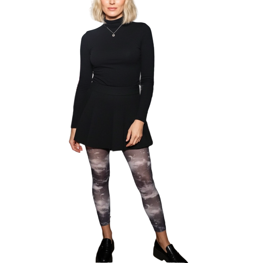 Woman in black outfit standing in an auditorium with stage lights in the background