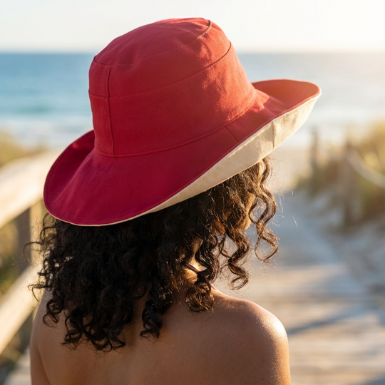 Person wearing a red and beige hat on a beach