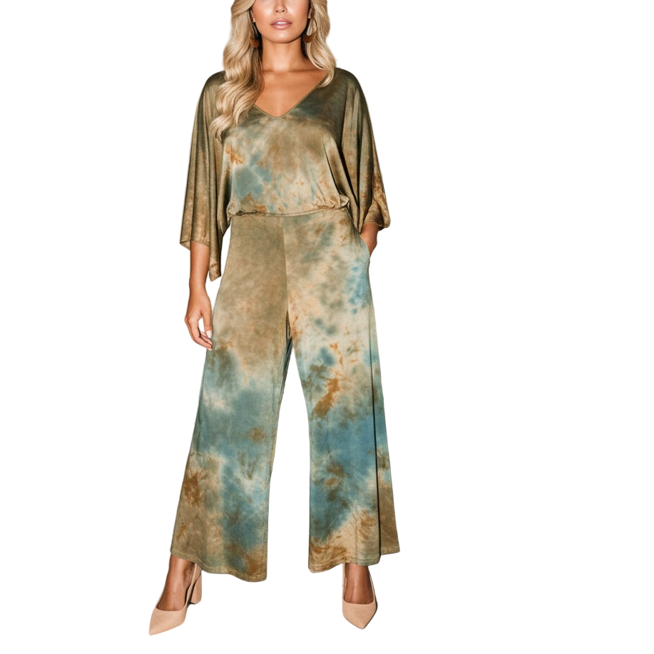 Woman in a tie-dye jumpsuit standing in an art gallery with abstract paintings on the wall.