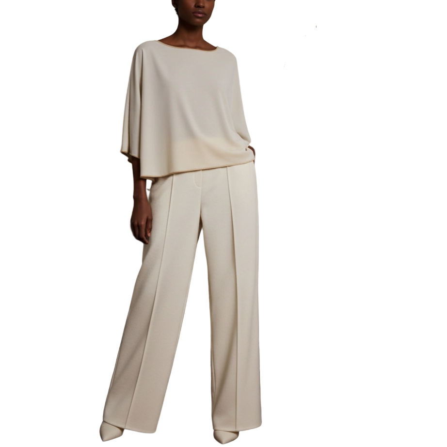 Woman in a white outfit standing in a room with a lamp and chair.