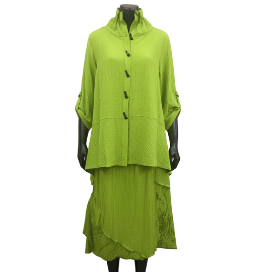 Mannequin wearing a green outfit with a pink curtain background