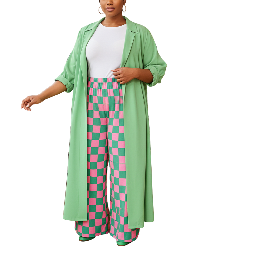 Woman in a green coat and pink checkered pants standing in a modern restaurant.