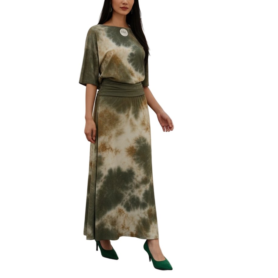 Woman in a tie-dye dress standing in an art gallery with paintings on the wall.