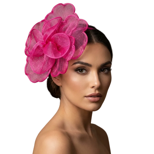 Woman wearing a bright pink floral headpiece against a neutral background