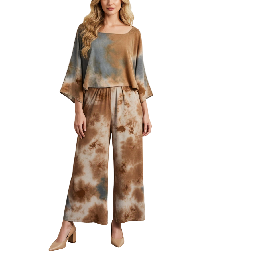 Woman in a tie-dye outfit standing in an art gallery with paintings and sculptures on the walls.