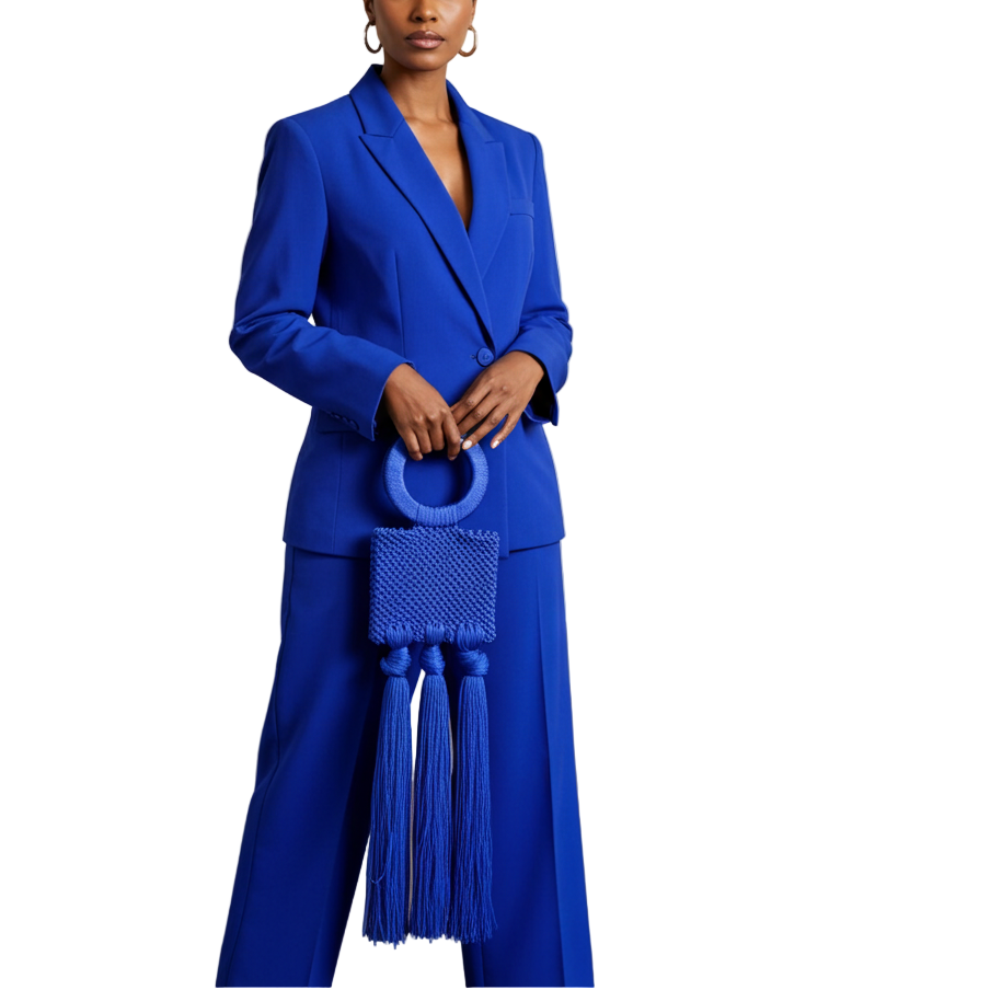 Woman in a blue suit holding a matching blue handbag in an art gallery.