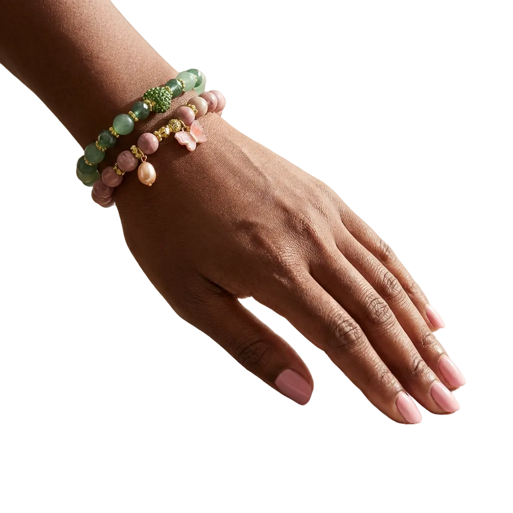 Hand wearing multiple beaded bracelets on a soft surface with a blurred background