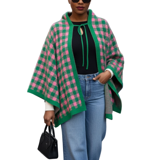 Woman wearing a green and pink checkered cape in an outdoor market setting