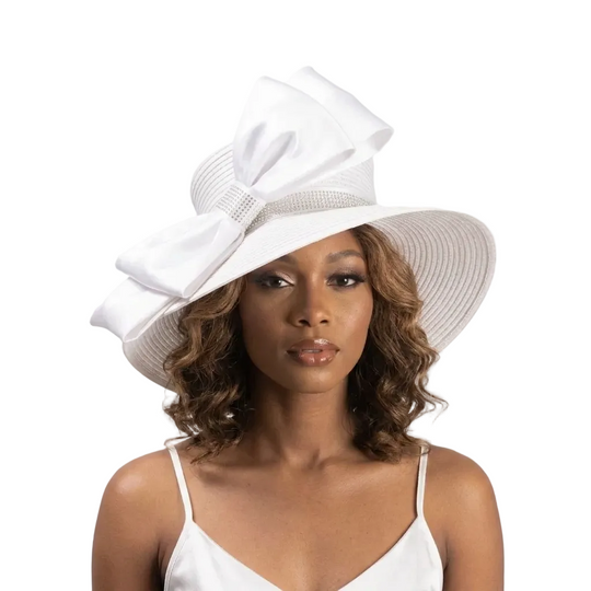 Woman wearing a white hat with a large bow on a light gray background