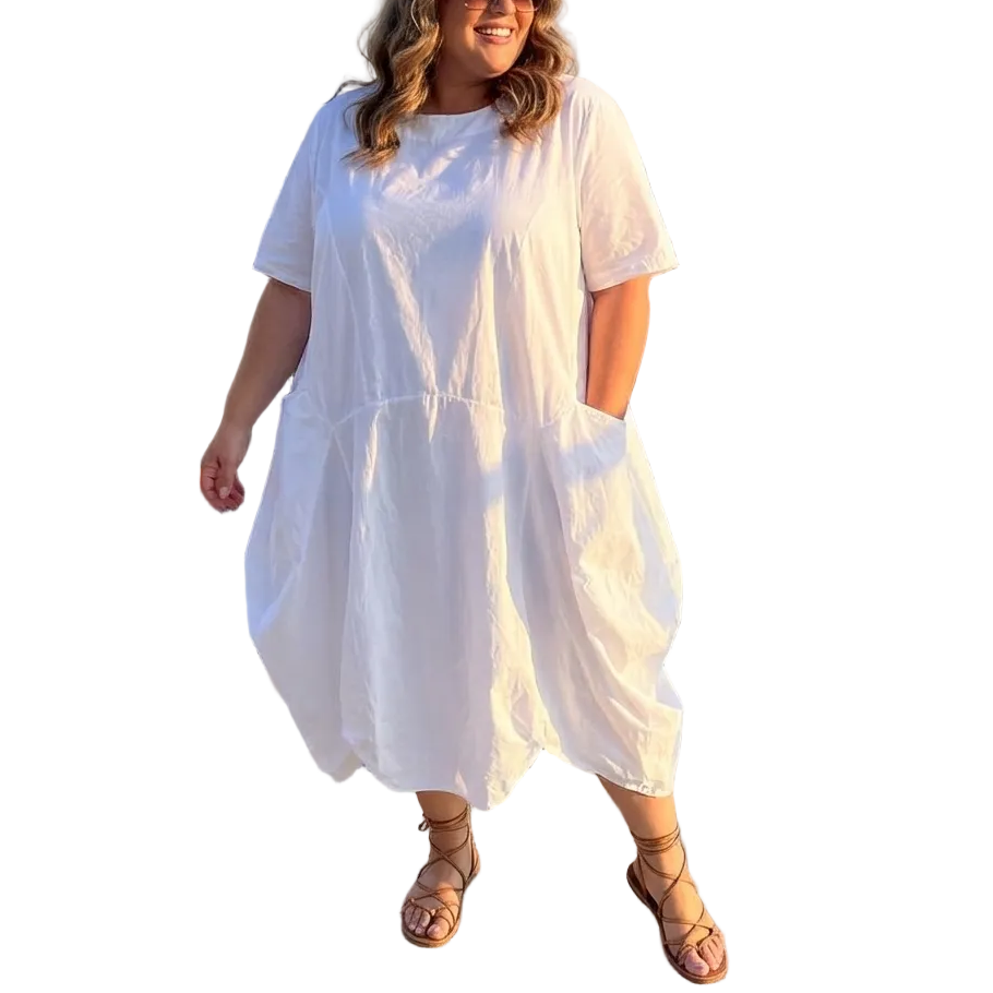 Woman in a white dress standing on a rooftop with cityscape background