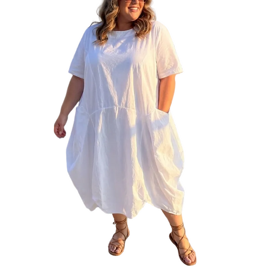 Woman in a white dress standing on a rooftop with cityscape background