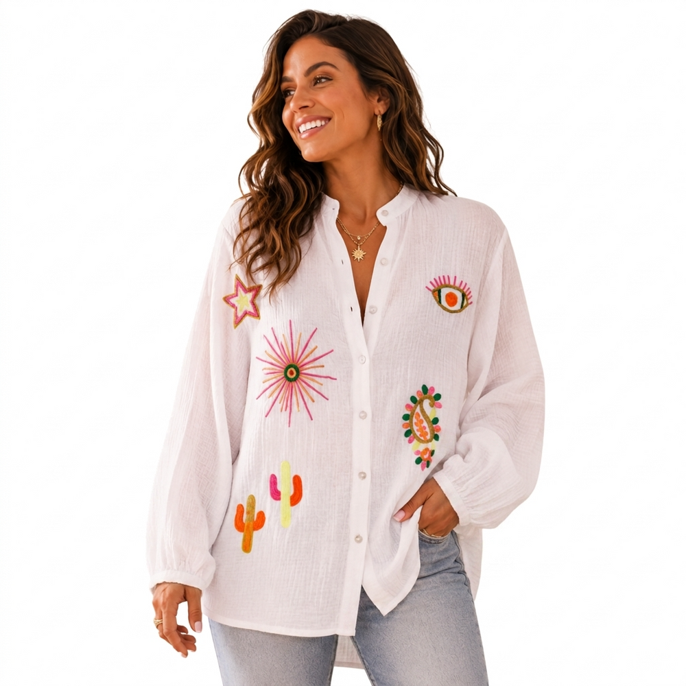 Woman wearing a white embroidered shirt with colorful designs on a white background