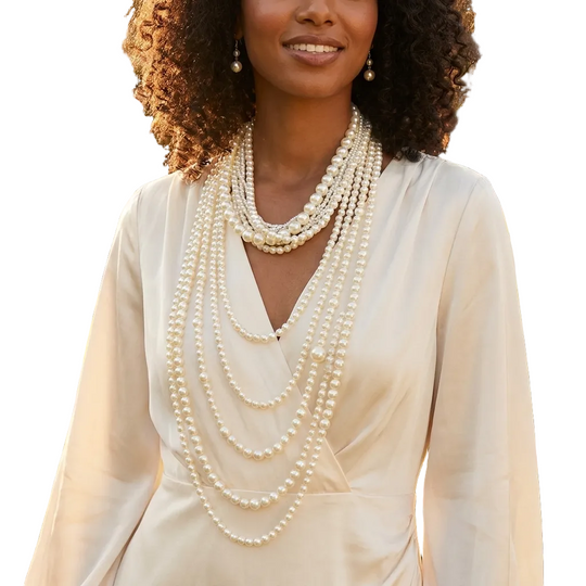 Woman wearing multiple pearl necklaces in a garden setting