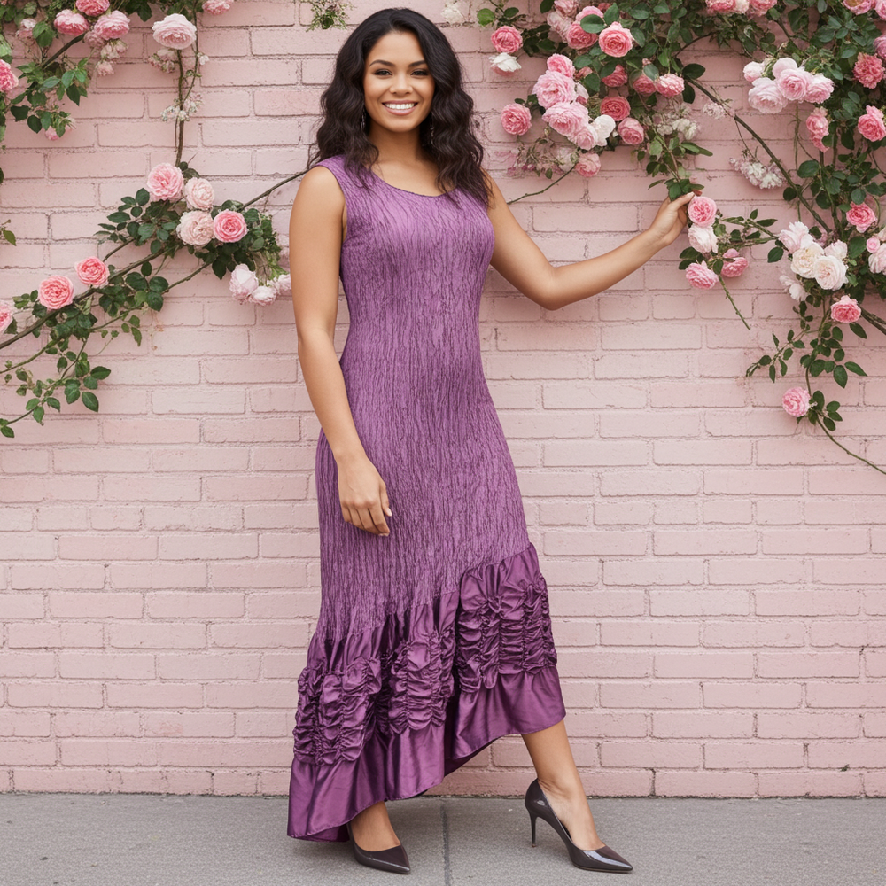 Woman in a purple dress standing against a pink brick wall with floral decorations