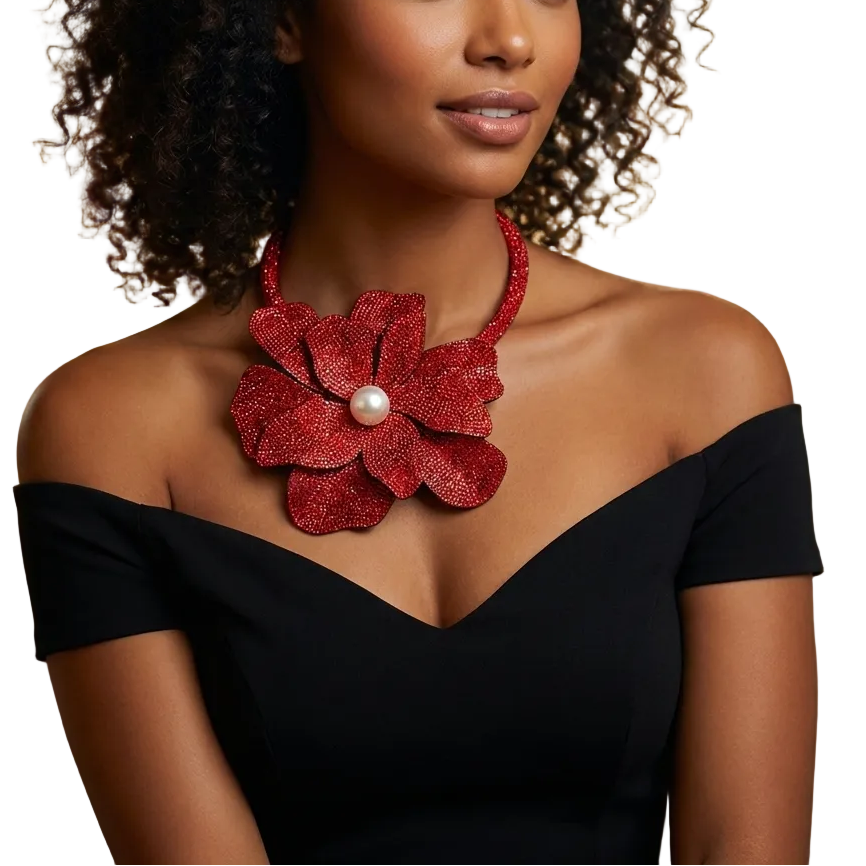 Woman wearing a black off-shoulder top with a large red floral necklace.