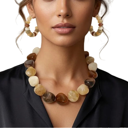 Woman wearing a necklace and earrings with a neutral background