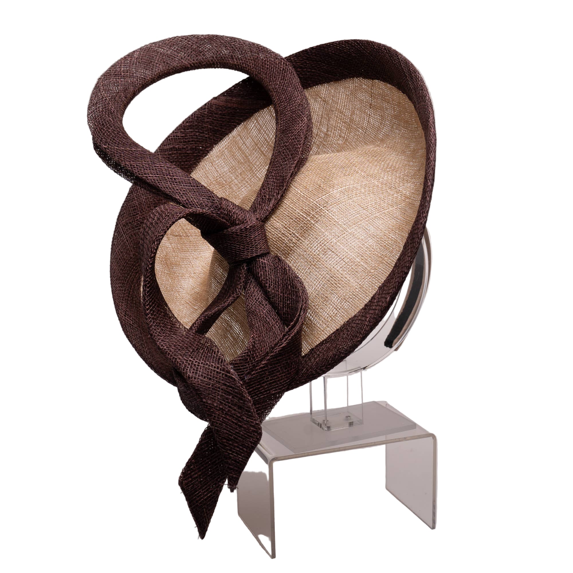 Brown and beige decorative hat on a stand against a plain background