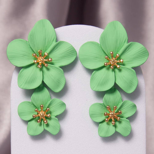 Green floral earrings with gold centers on a white background