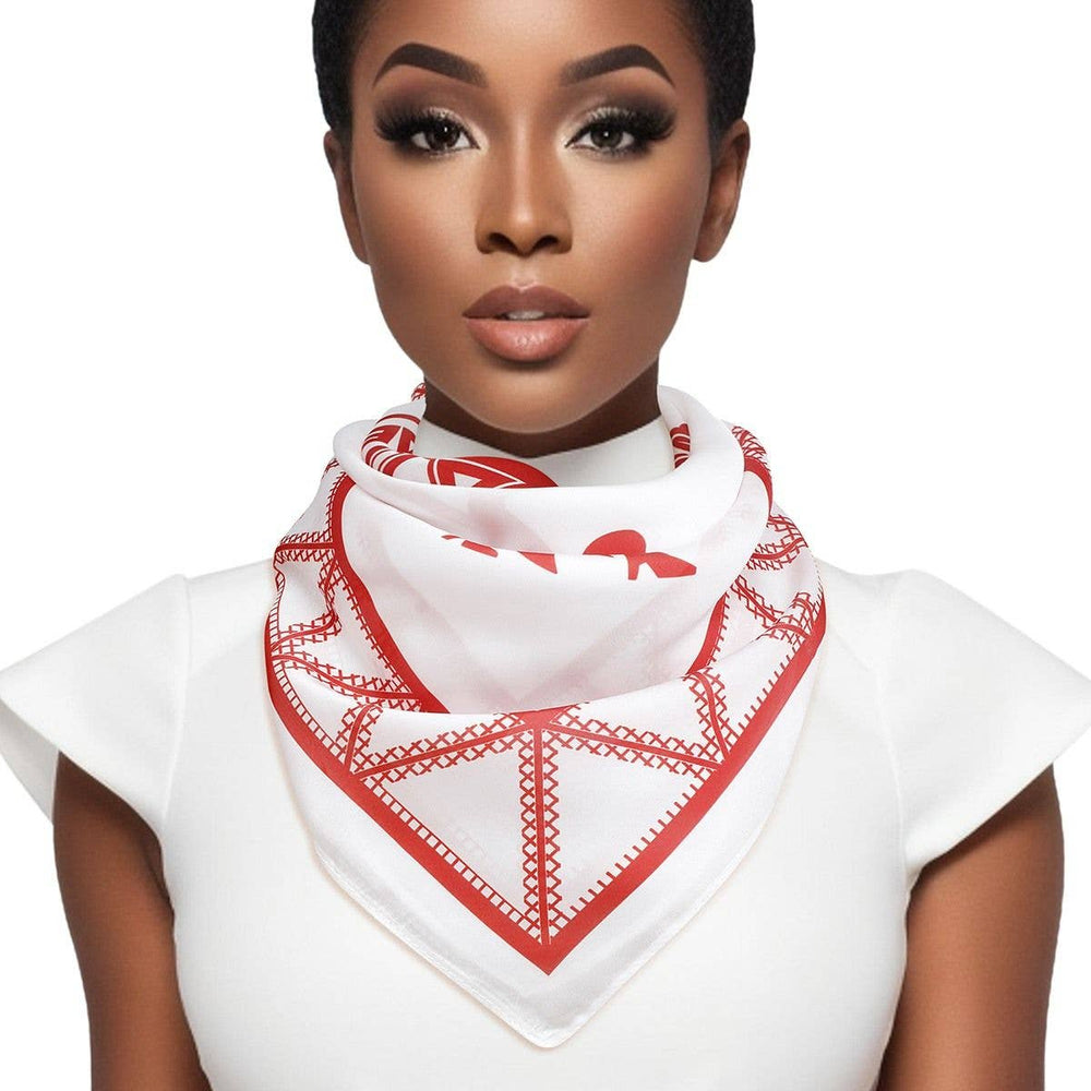 Woman wearing a white top with a red and white patterned scarf