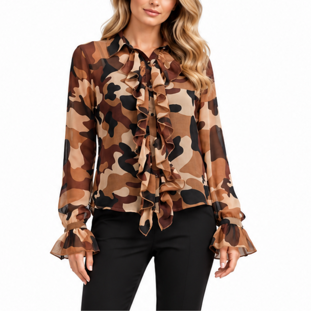 A woman modeling a long-sleeve camouflage print blouse with a ruffled tie-neck detail and ruffled cuffs, paired with black pants, against a plain white background.