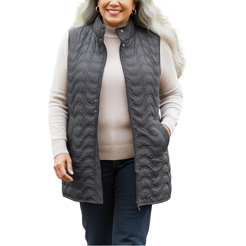 Woman wearing a gray quilted vest in a park with trees and grass.