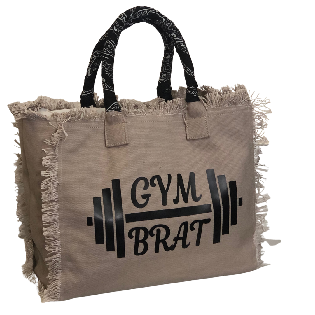 Gym Brat Shoulder Tote - Bandana - Beige
We have improved this best-selling bag! Now larger and roomier it's a shoulder tote and fully lined too! Fringe Bag Perfect everyday bag! - "Gym Brat" Fully lined canvas tote with soft-support bottom and bandana covered handles. Inside bag has 1 convenient inside zippered pockets and 2 insert pockets. Bag handles are at 7.5" drop and fits comfortably around the shoulder. Dimensions: 12"X14"X6.5" Made in USA
Gym Brat Shoulder Tote - Bandana - Beige
Gym Brat, fully lin