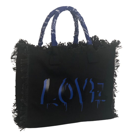 Dripping LOVE Shoulder Tote - Blue
We have improved this best-selling bag! Now larger and roomier it's a shoulder tote and fully lined too! Fringe Bag Perfect everyday bag! - We say around here that you are just, "dripping LOVE" Fully lined canvas tote with soft-support bottom and bandana covered handles. Inside bag has 1 convenient inside zippered pockets and 2 insert pockets. Bag handles are at 7.5" drop and fits comfortably around the shoulder. Dimensions: 12"X14"X6.5" Made in USA Tee shirt available und