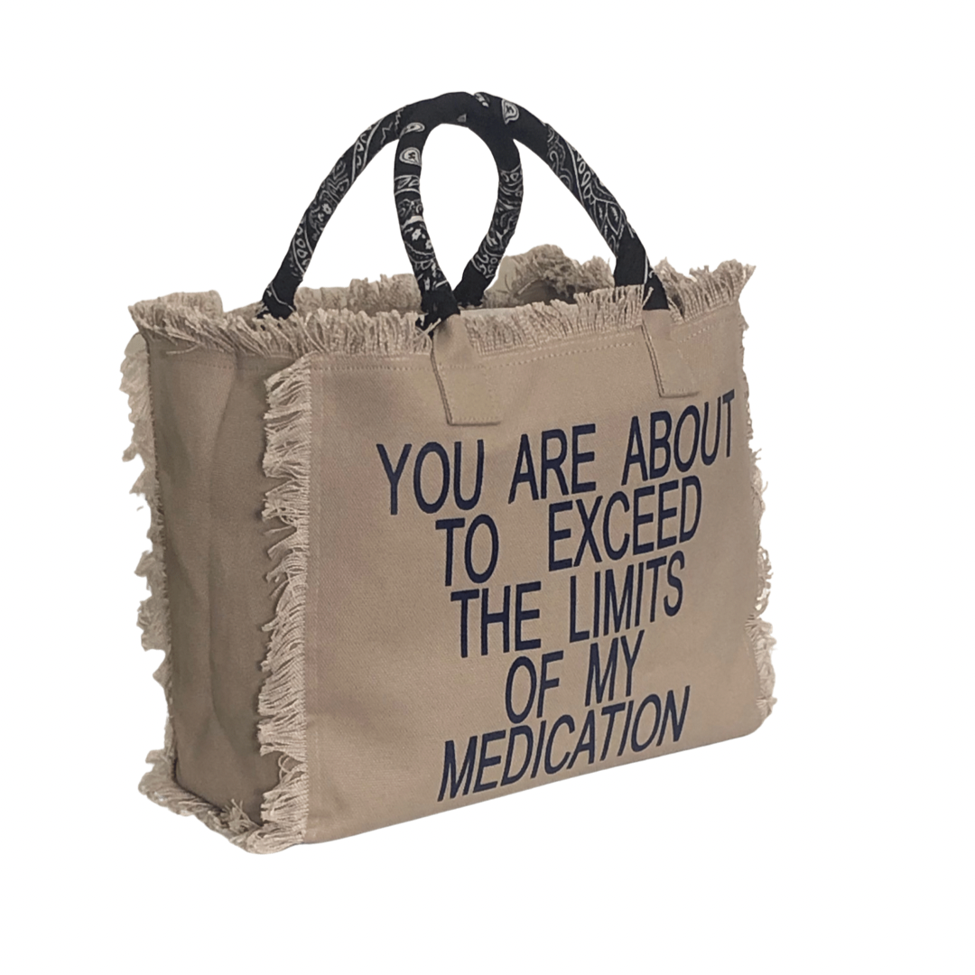 Limits Shoulder Tote - Beige/Black
We have improved this best-selling bag! Now larger and roomier it's a shoulder tote and fully lined too! Fringe Bag Perfect everyday bag! - "You Are About to Exceed My Medication" Fully lined canvas tote with soft-support bottom and bandana covered handles. Inside bag has 1 convenient inside zippered pockets and 2 insert pockets. Bag handles are at 7.5" drop and fits comfortably around the shoulder. Dimensions: 12"X14"X6.5" Made in USA
Limits Shoulder Tote - Beige/Black
Ex