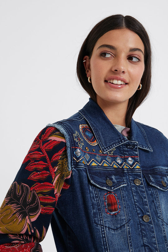 Removable Collar Mixed Fabric Denim Jacket - Desigual.
A jacket for playing. Because this bimaterial trucker jacket in denim fabric and knit sleeves in floral print has a removable synthetic fur collar that goes with all your looks. The friezes on the side hem and shoulder with tears, enrich the garment, making it unique. Removable synthetic fur collar Metallic fasteners Tricot sleeves of flowers in orange tones Frayed finish on shoulders Thick winter lining Slim fit Do not bleach Machine Wash Cold water Do