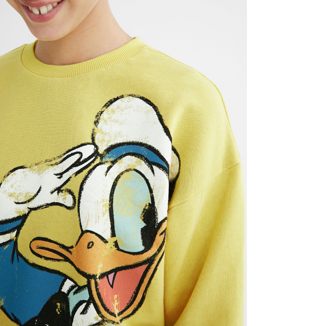Vintage Inspired Sweatshirt - Donald Duck
This fine cotton sweatshirt with vintage illustration of Donald Duck livens up any casual everyday look. With frayed hem, it's a trendy and very fun top. With collar and cuffs finished in ribbing. Matching ribbed round neck Vintage style Donald Duck front illustration Yellow background Matching ribbed neck, cuffs and hem Mickey Mouse capsule Regular fit Long sleeve Fabric & Care: 99% cotton 1% elastane Do not bleach Cool iron on reverse side Do not dry clean Do not